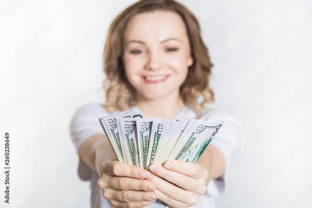 Happy young smiling woman hold us dollar money in hand over white background. Happy young smiling woman hold us dollar money in hand over white background.