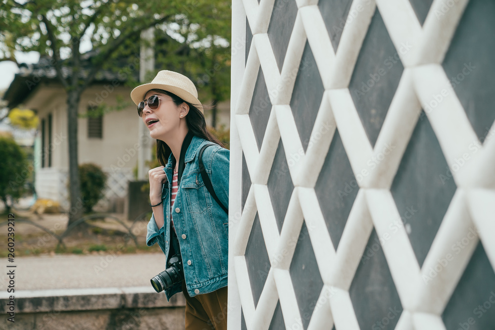 Smiling girl travel photographer with camera pop head walking by rhombic wall. happy woman wear sunglasses straw hat looking around sightseeing in osaka castle outdoor sunny day japan in spring park