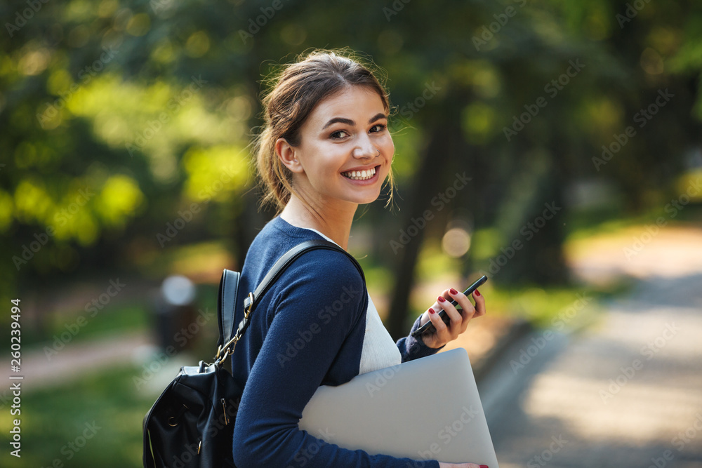 © Drobot Dean - Smiling young teenage girl carrying backpack walking