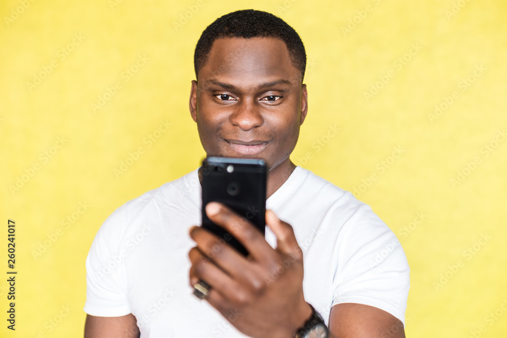 African American man taking pictures on a smartphone. African American man taking pictures on a smartphone.