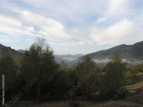 Mountain landscape with blue sky. View of the mountains and green hills from above.