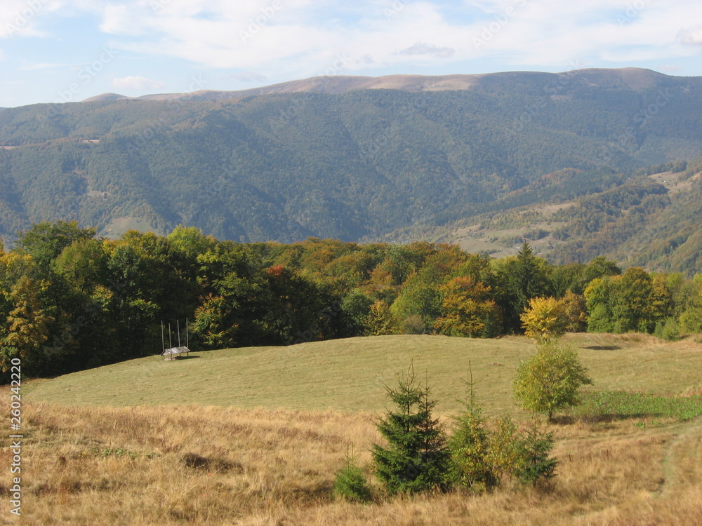 Mountain landscape with blue sky. View of the mountains and green hills from above. Mountain landscape with blue sky. View of the mountains and green hills from above.