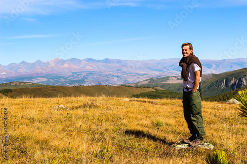 Tourist posing for photos on the background of the autumn landscape of the Altai mountains