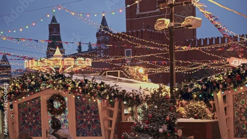 MOSCOW, RUSSIA - DECEMBER 6: Christmas fair in Moscow center on Red Square. Moscow Kremlin at winter night at Christmas fair. Gimbal pan shot of Moscow fair in snowing windy weather