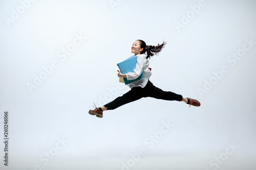 Best place for good emotions. Happy woman working at office, jumping and dancing in casual clothes or suit isolated on white studio background. Business, start-up, working open-space concept.