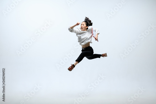 New ideas can't wait - let's realize. Happy woman working at office, jumping and dancing in casual clothes or suit isolated on white studio background. Business, start-up, working open-space concept. © master1305