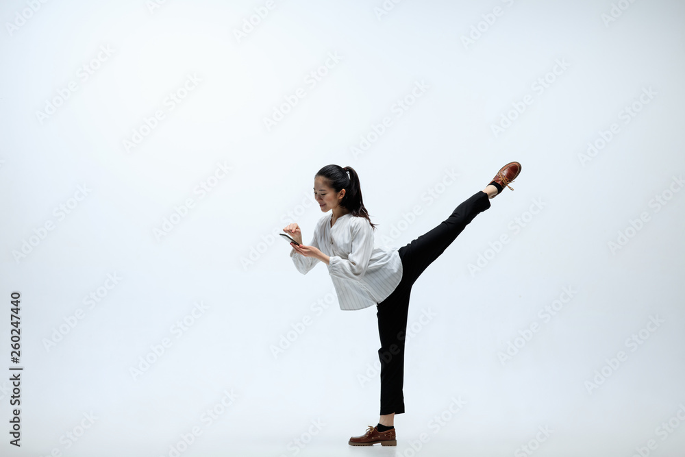 Give your right answer for better. Happy woman working at office, jumping and dancing in casual clothes or suit isolated on white studio background. Business, start-up, working open-space concept. Give your right answer for better. Happy woman working at office, jumping and dancing in casual clothes or suit isolated on white studio background. Business, start-up, working open-space concept.