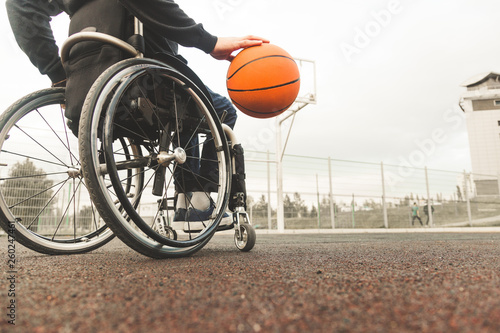 Young man in a wheelchair playing basketball.