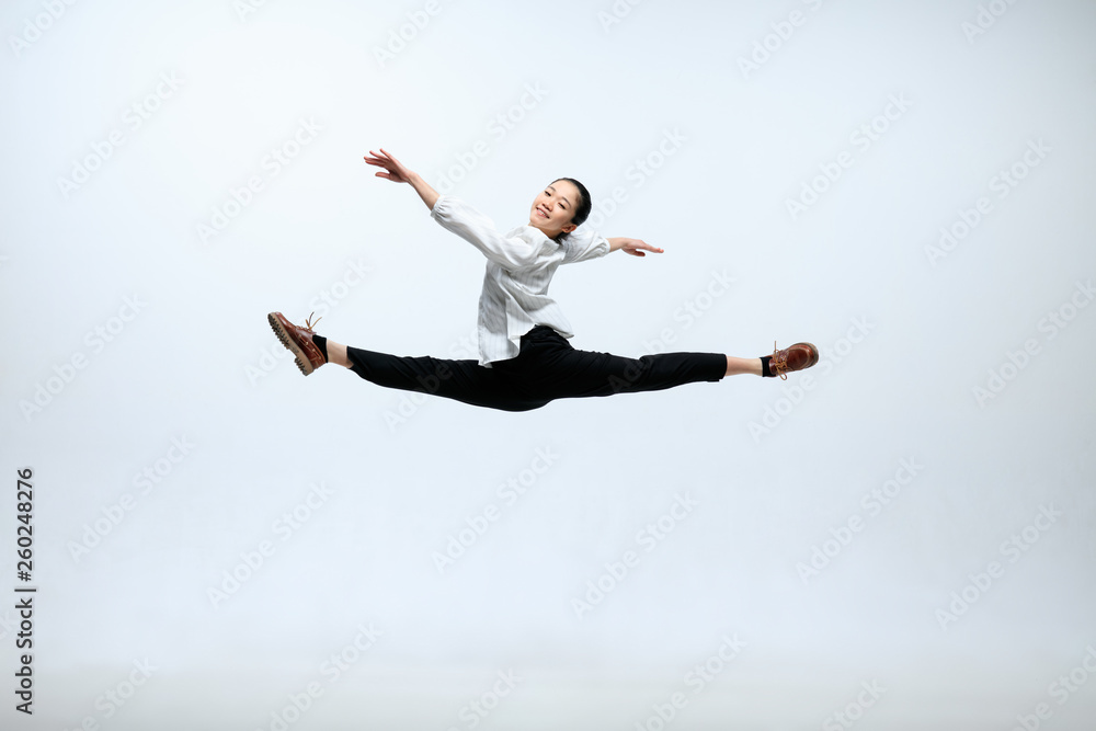 Fly for your target faster, than others. Happy woman working at office, jumping and dancing in casual clothes isolated on white studio background. Business, start-up, working open-space concept.