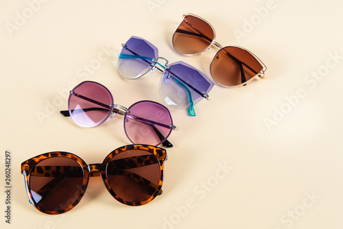 Different sunglasses on yellow background. Summer banner. Copy space.