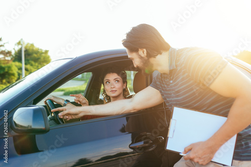 Driving school or test. Beautiful young woman learning how to drive car together with her instructor. © hedgehog94