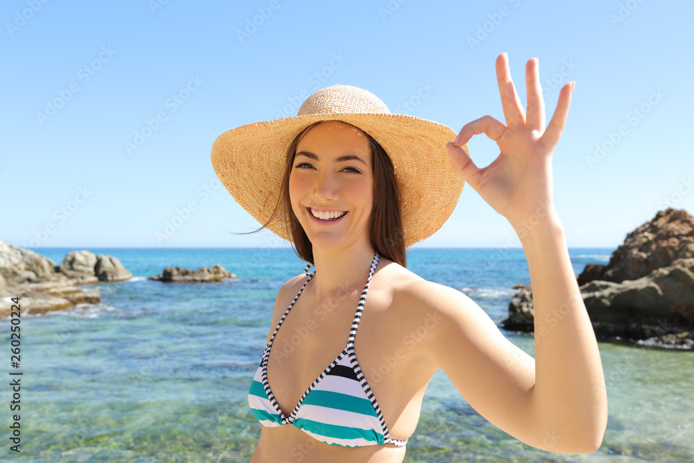 Happy tourist on the beach gesturing ok sign