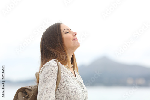 Happy woman on the beach breathing fresh air