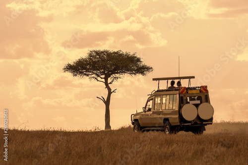 Tourist on safari adventure at sunset, Maasai Mara, Kenya