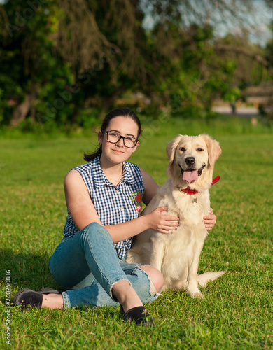 Portrait of young beautiful woman lying and hugging her Labrador retriever dog. Happiness and friendship. pet and woman.