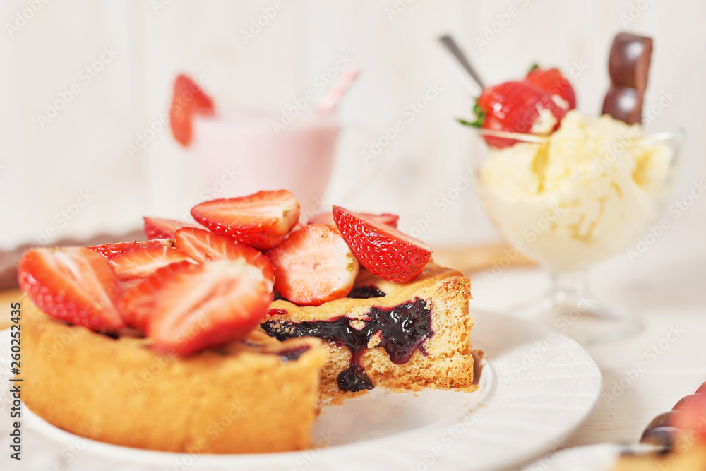 Strawberry cake and chocolate bars on a white wooden background. Strawberry cake and chocolate bars on a white wooden background.