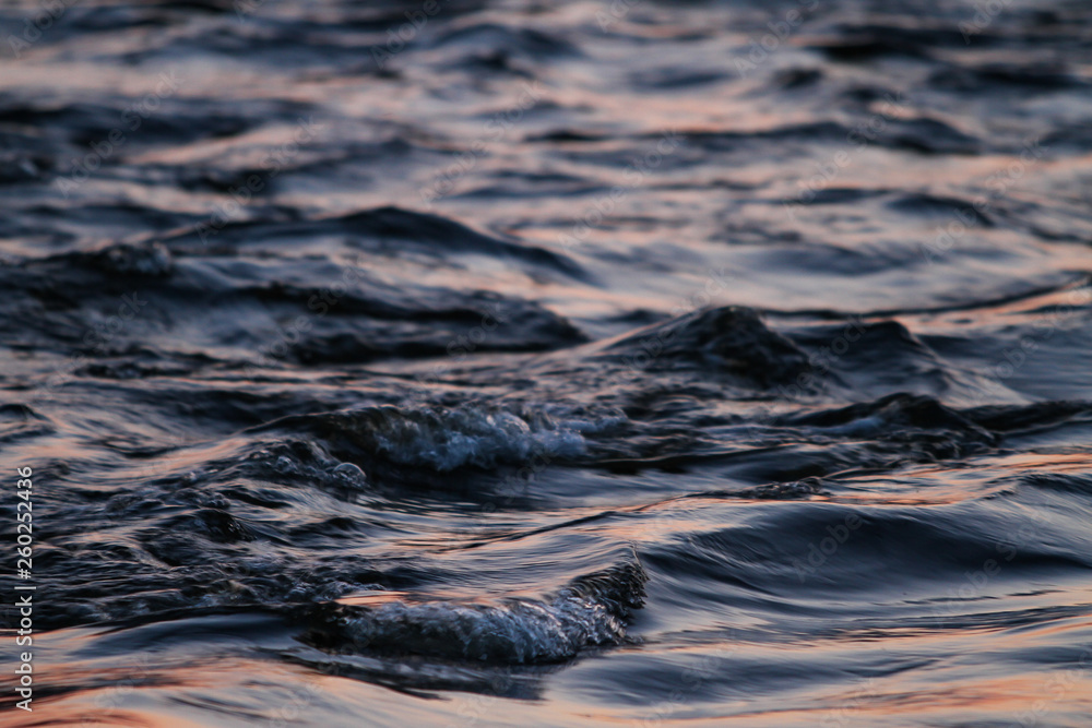 Obraz premium Beautiful sunset reflection view with river flowing with small waves.