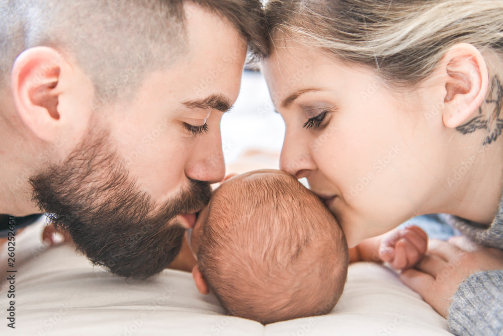family lay on bed with his newborn baby daughter family lay on bed with his newborn baby daughter