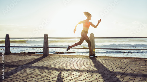 Fototapeta Naklejka Na Ścianę i Meble -  Woman sprinting during sunset