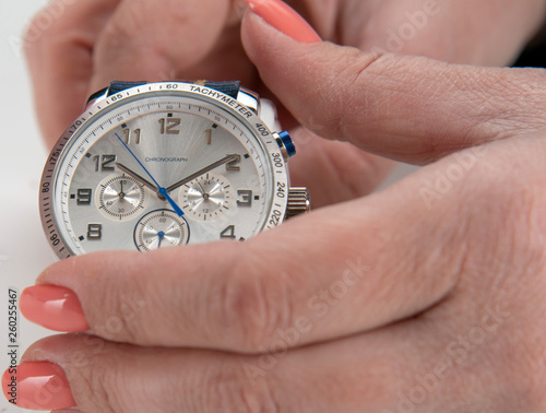 Men's wrist watch with silver dial colored strap on gray background.