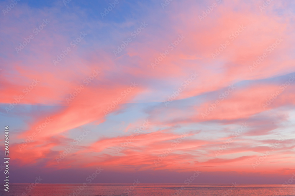 View of the blue-pink sky with clouds at sunset in the background of the sea. Beautiful natural layout