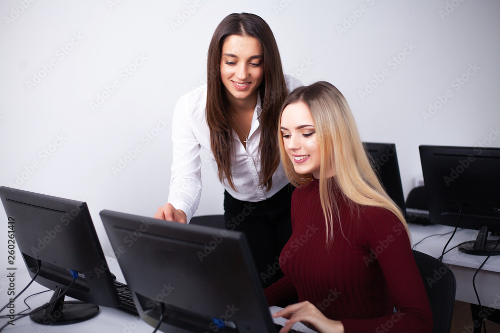 Two female colleagues in office working together. Two female colleagues in office working together Two female colleagues in office working together. Two female colleagues in office working together