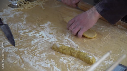 Pasta cutting machine for preparing fresh spaghetti, pasta coming out of pasta machine close-up