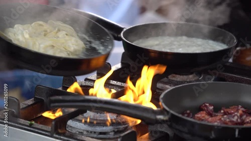 Frying pan on fire, chef Frying vegetables on fire throwing them in a frying pan.