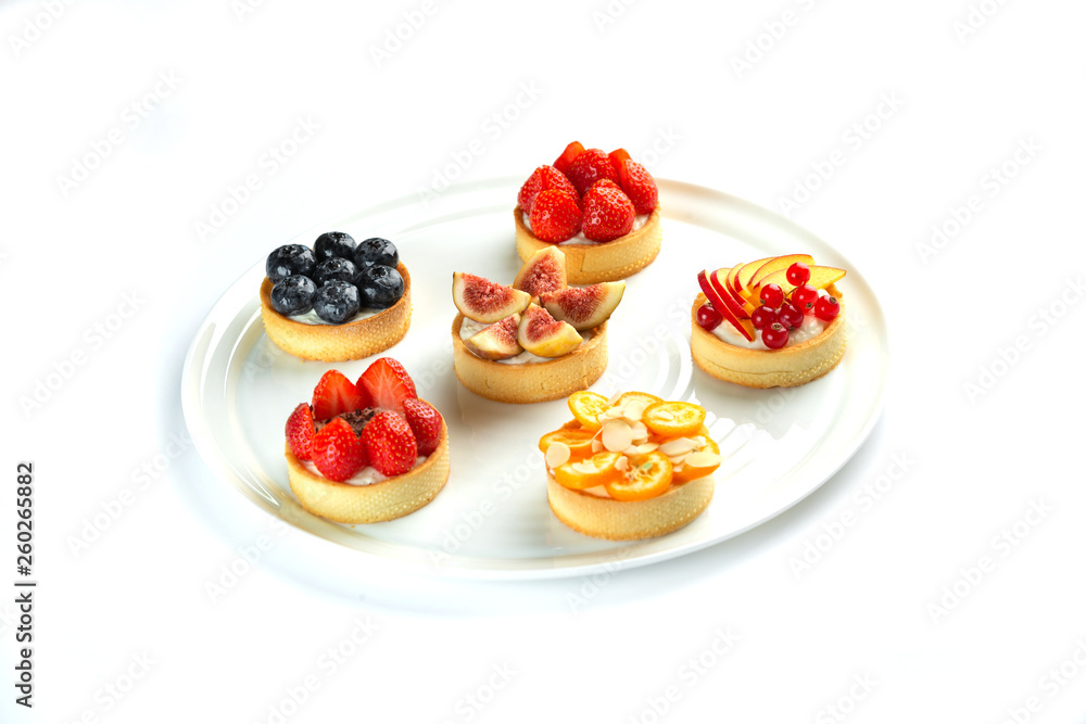 tartlets with fruits and berries in a plate on an isolated white background tartlets with fruits and berries in a plate on an isolated white background