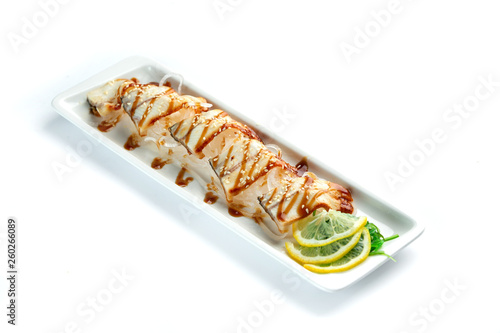 pieces of white fish with lemon and herbs on a rectangular plate on an isolated white background