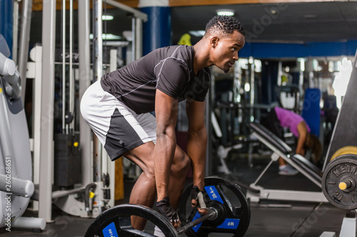 Black African American young man doing workout at the gym