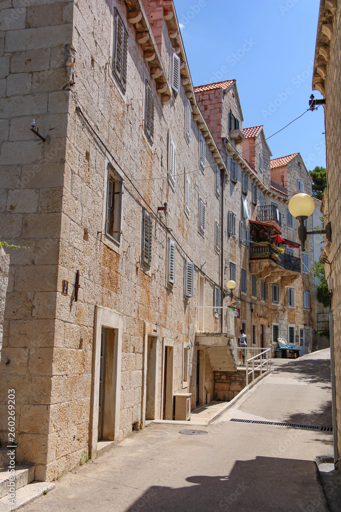 Tipical stone houses on narrow street in the old town of Bol on island Brac Croatia
