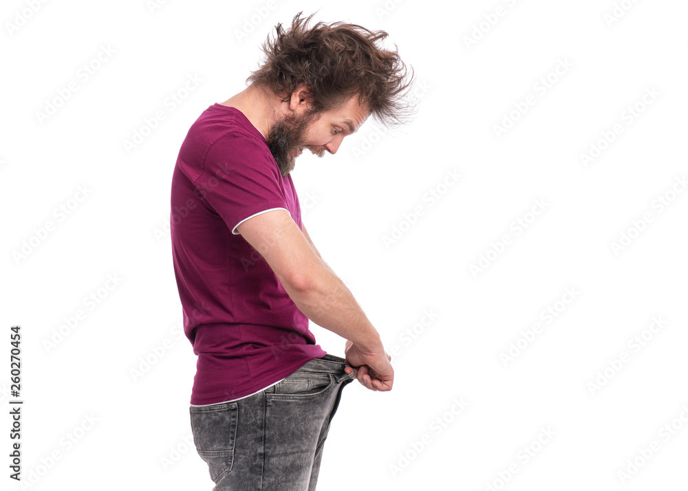 Crazy bearded Man with funny Haircut shows his weight loss by wearing an old  jeans, isolated on white background. Surprised or shocked guy. Healthy  Dieting or workouts concept. Stock Photo | Adobe