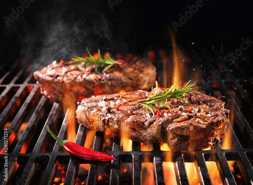 Beef steaks sizzling on the grill