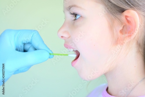 pediatrician using a cotton swab to take a sample from a girl throat. close up of scientist hand holding swab to collect dna of a little patient. making research a test dna molecule structure