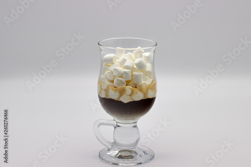Coffee And Many Small Marshmallows In A Transparent Glass Cup On A Gray Background