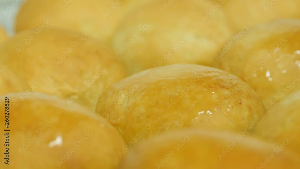Close Up Of Kolache Round Bread Roles Being Buttered. Freshly baked bread is brushed with melted butter. Close Up Of Kolache Round Bread Roles Being Buttered. Freshly baked bread is brushed with melted butter.
