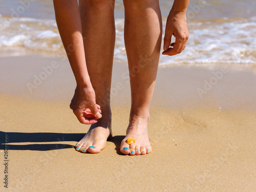 Woman at the beach with a shell on her foot