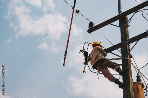 The power lineman uses insutated tool to open the connection of the transformer from the high voltage distribution system. To change the surge arrester that protects the transformer. photo