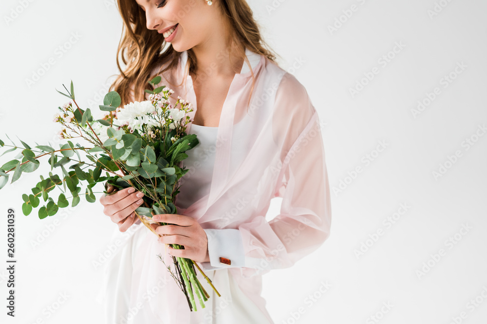 cropped view of happy girl holding flowers with green eucalyptus leaves on white cropped view of happy girl holding flowers with green eucalyptus leaves on white