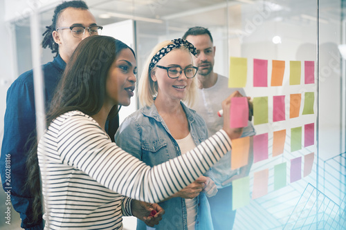 Smiling coworkers brainstorming with sticky notes in an office