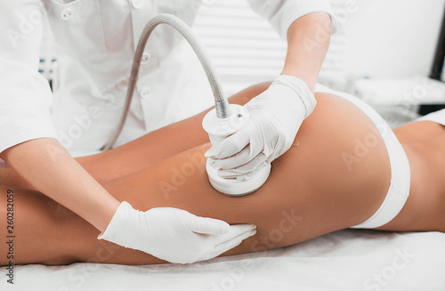 woman having cavitation, procedure removing cellulite on her buttocks , lifting buttocks photo