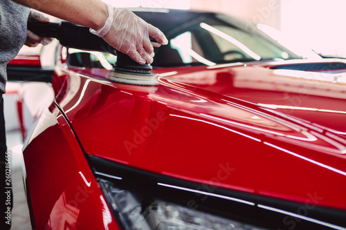 Car detailing - Worker with orbital polisher in auto repair shop. © hedgehog94
