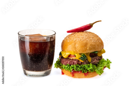 Tasty cheeseburger and a glass of coke with ice. Ingredients - grilled cutlet, sesame bun, tomato, onion, fresh lettuce and red chili peppers isolated on white background. Fastfood concept