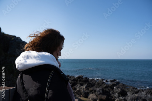Asian chinese girl japanese style standing by the sea looking at the horizon