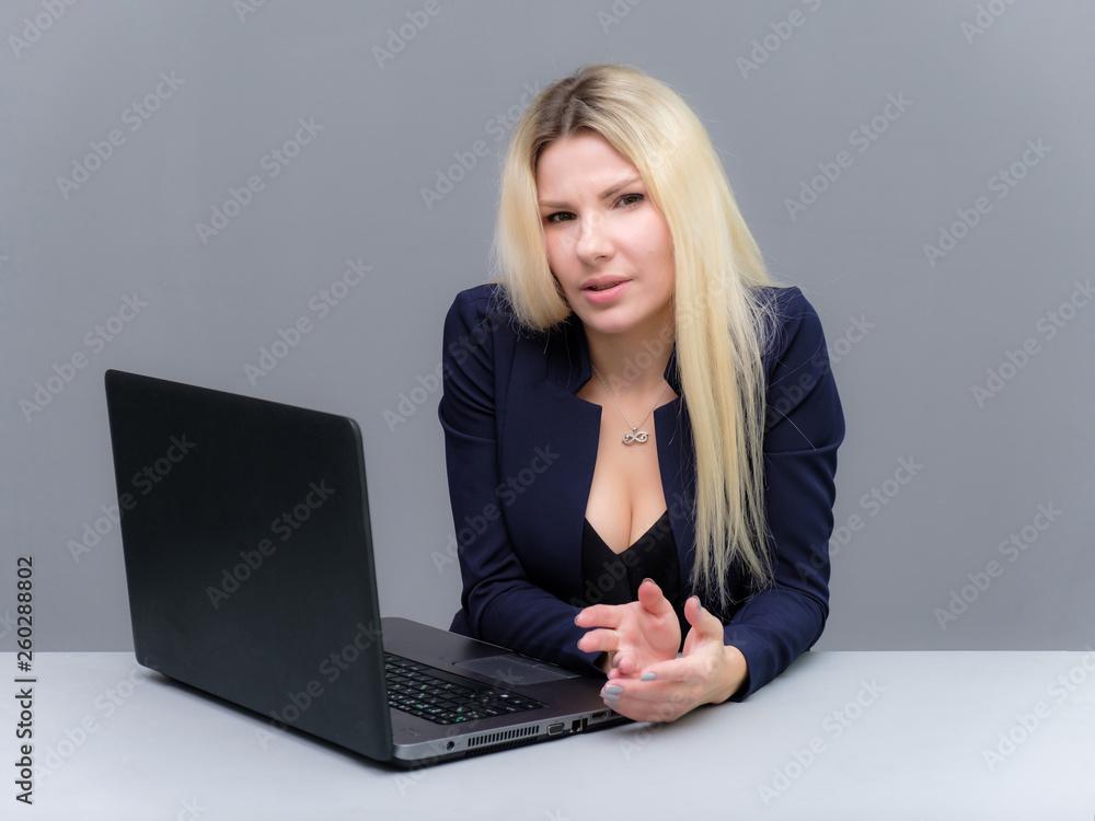 Portrait of happy smiling young cheerful businesswoman sitting with a laptop. Success in business concept studio shot talking to a client. Portrait of happy smiling young cheerful businesswoman sitting with a laptop. Success in business concept studio shot talking to a client.