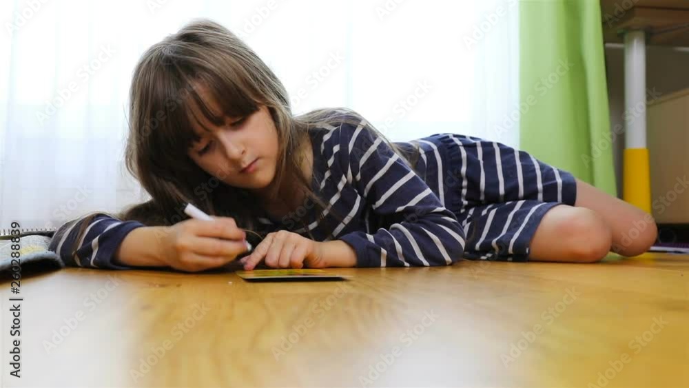 young brunette passionately draws lying on the floor. young brunette passionately draws lying on the floor.