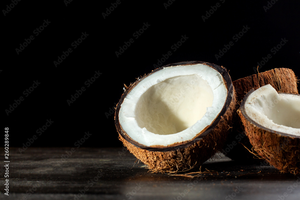 Coconut halves on a black background. Back light. Coconut halves on a black background. Back light.