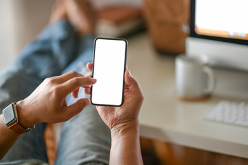 Business man hand holding white  blank mobile phone in office