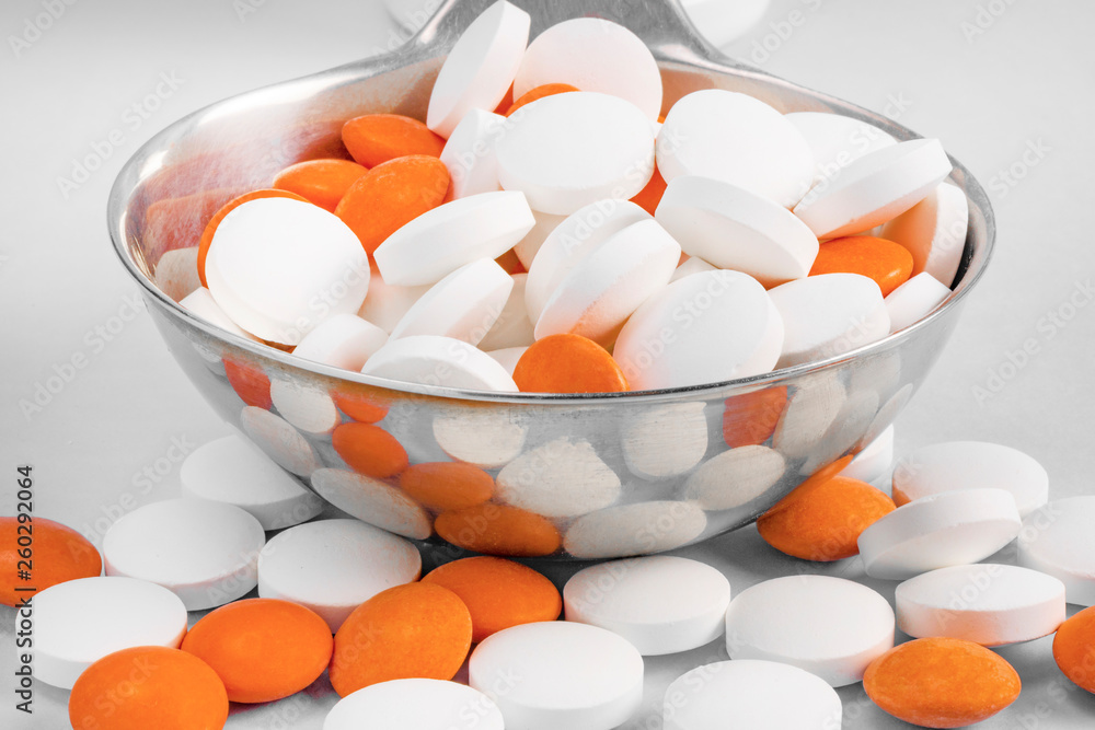 pill in a ladle on a gray background pill in a ladle on a gray background